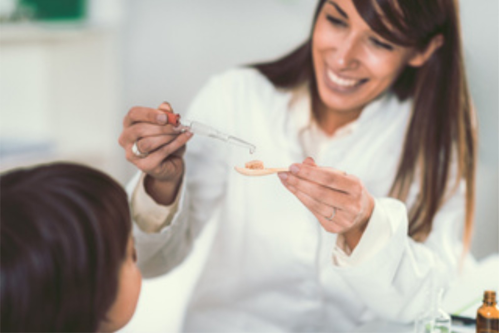Practitioner measuring a liquid herbal formula, the last step rather than the first